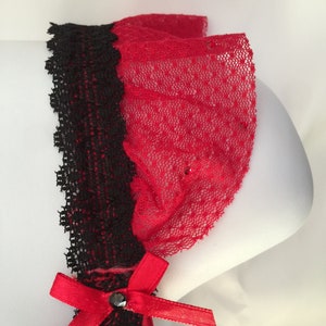 May include: Red and black lace garter with a red satin bow and a black rhinestone.