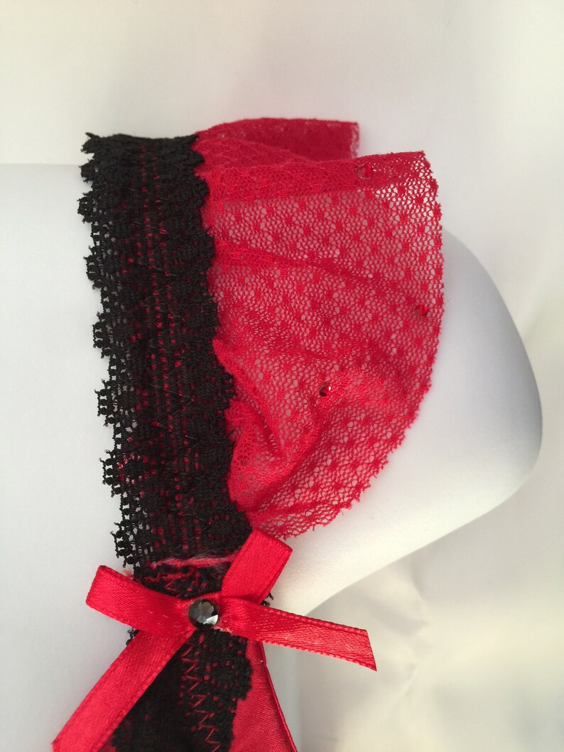 May include: Red and black lace garter with a red satin bow and a black rhinestone.