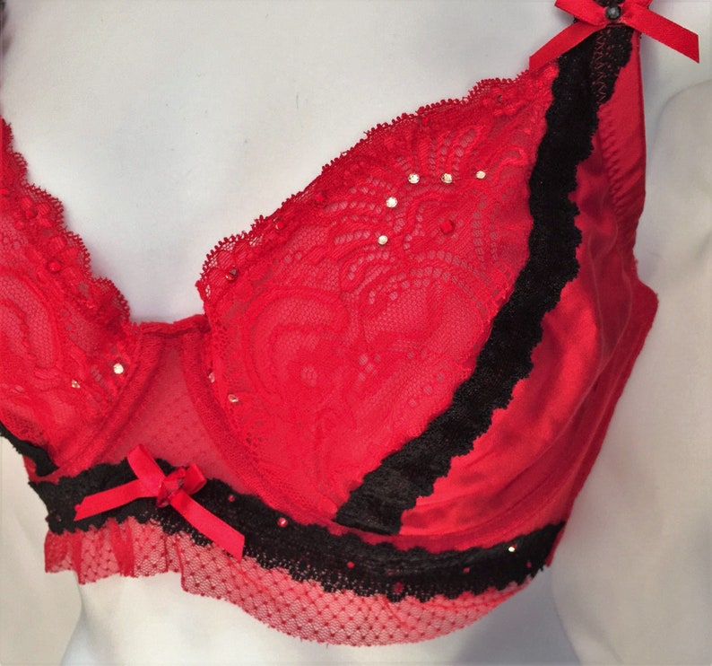 May include: Red lace bra with black trim and rhinestones.