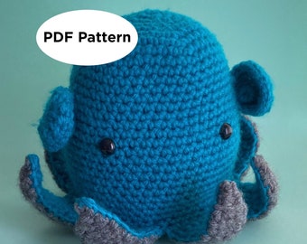 Op de afbeelding: Een gehaakt octopus knuffel met een blauw lichaam en grijze tentakels. De octopus heeft zwarte ogen en een vriendelijke uitdrukking. De tekst "PDF Pattern" is zichtbaar in de afbeelding.