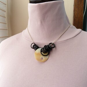 Vintage carved shell button pendant with rubber gaskets on Sterling Ball Chain
