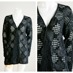 May include: Black crochet cardigan with a long, open front and a delicate, lacy pattern.