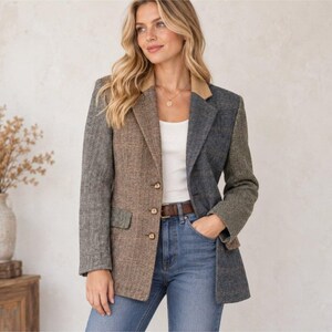 May include: A color-blocked blazer featuring a herringbone pattern in shades of brown, gray, and olive green. The garment has a tan collar, three front buttons, and two flap pockets. It is worn over a white tank top and blue denim jeans.