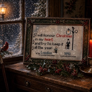 May include: A framed cross-stitch embroidery featuring the text 'I will honour Christmas in my heart, and try to keep it all the year', 'London', '1843', and 'A Christmas Carol' by Charles Dickens, with a silhouette of a person and a streetlamp.