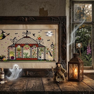 May include: A framed cross-stitch embroidery depicting a greenhouse scene with a witch, a pumpkin, and bats, housed in a dark ornate frame. The artwork features black, red, and green thread details on a beige fabric background, displayed with a lantern.