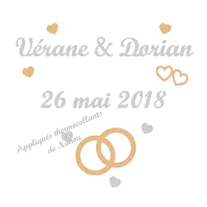 Peut inclure: Fond blanc avec texte argenté pailleté « Vérane & Dorian » et « 26 mai 2018 ». Des cœurs et des anneaux entrelacés dorés et argentés sont également présents. Le texte « Appliqués thermocollants de Nanou » est également inclus.