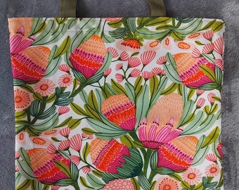 May include: A tote bag with a floral pattern featuring pink, orange, and green flowers on a white background. The bag has olive green handles. The floral design includes detailed illustrations of various flowers and foliage.