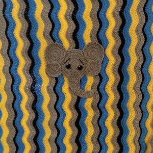 May include: A crocheted baby blanket featuring a grey elephant applique. The blanket is made with yellow, blue, grey, and black yarn in a wavy pattern.