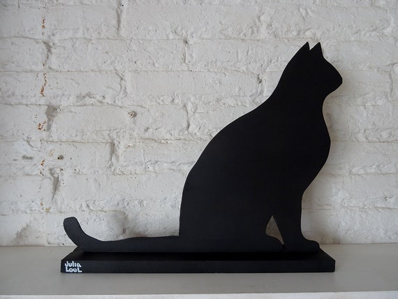 SITTING CAT. Street art. A black cat by Valencian artist Julia Lool, made of MDF.