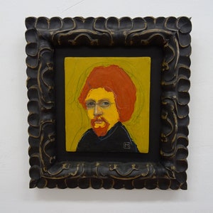 May include: A framed portrait painting of a person with a red beard and red hair. The person is wearing a black shirt and has a yellow face. The painting is set against a yellow background.