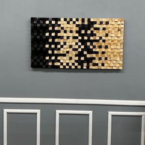 May include: A rectangular wooden wall art piece with a gradient design. The left side is black, transitioning to natural wood tones on the right. The artwork is composed of small, square wooden blocks, creating a textured surface.