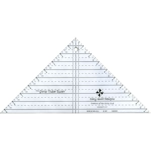 May include: A clear plastic triangle ruler with markings in inches. The ruler is labeled "The Strip Tube Ruler" and "Cozy Quilt Designs".