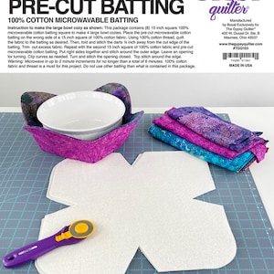 Peut inclure: Un kit de molleton prédécoupé pour la fabrication de grands coussins pour bols. Le kit comprend du molleton prédécoupé blanc, du tissu à motifs, un cutter rotatif violet et un bol blanc. Le texte sur l'emballage indique "Large Bowl Cozy".