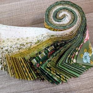 Peut inclure: Un rouleau de bandes de tissu vert et blanc avec différents motifs floraux et géométriques. Le tissu est déroulé pour montrer les différents motifs.