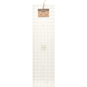 May include: A clear plastic quilting ruler with a grid pattern. The ruler is 61 cm long and has markings in inches and fractions of an inch. The ruler is labelled "Hamilton Gold" and "Lasercut".