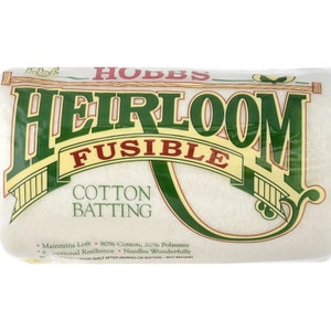 Peut inclure: Un paquet de ouate de coton Hobbs Heirloom Fusible, de couleur blanche avec des lettres vertes et dorées. L'emballage indique que la ouate est composée de 80 % de coton et de 20 % de polyester. Il indique également que la ouate conserve son gonflant, a une résistance exceptionnelle et se pique merveilleusement.