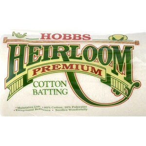 Könnte beinhalten: Eine weiße Packung Hobbs Heirloom Premium Baumwolle. Die Packung ist mit grünem Text und einem grün-gelben Logo beschriftet. Der Text auf der Packung lautet: "Maintains Loft - 80% Cotton, 20% Polyester - Exceptional Resilience - Needles Wonderfully."