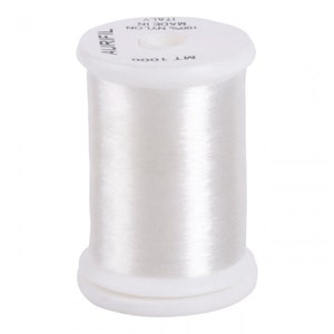 Peut inclure: Une bobine blanche de fil 100% nylon, étiquetée "AURIfil" et "MT 1000", fabriquée en Italie.