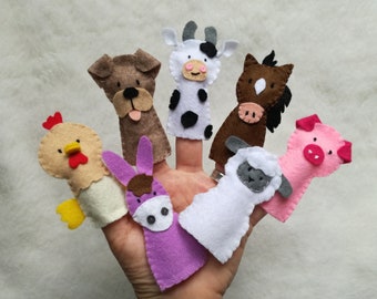 May include: Set of seven felt finger puppets featuring farm animals: a brown dog, a black and white cow, a brown horse, a pink pig, a white sheep, a purple donkey, and a yellow chick.