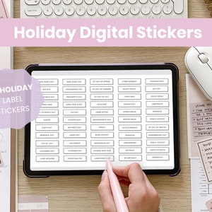 May include: A digital tablet displaying 54 holiday label stickers. The stickers are organized in rows and columns and feature various holidays, such as New Year's Day, Groundhog Day, President's Day, and more. The tablet is on a wooden surface with other office supplies, including a keyboard, mouse, and pens.
