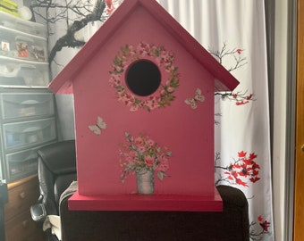 Casita para pájaros con temática rosa.