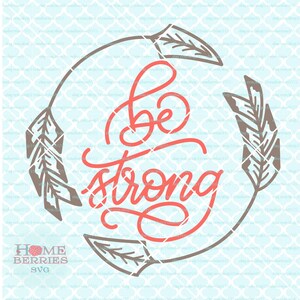 May include: A circular design with two brown arrows with feathers on each side. The text "Be Strong" is written in red cursive inside the circle.