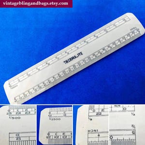 Könnte beinhalten: Ein weißes THERMAJITE-Lineal mit schwarzen Markierungen und Zahlen. Das Lineal ist mit Zoll und Zollbruchteilen markiert und hat auch einen Maßstab von 1/500 und 1/2500. Das Lineal ist etwa 30 cm lang.