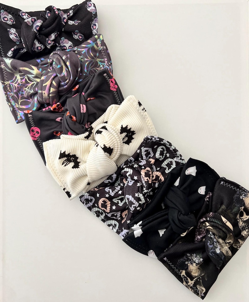 May include: Five Halloween-themed hair scrunchies in black and white with various patterns including skulls, bats, and ghosts.