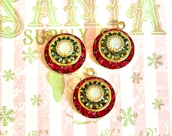 May include: Three gold-tone Christmas ornament charms with red and green glitter, a white center, and a gold loop for hanging.