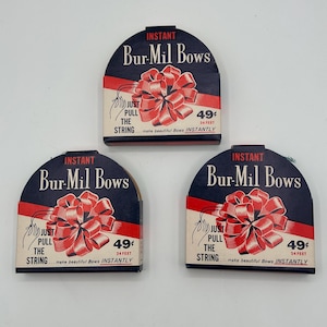 May include: Three vintage Bur-Mil Bows packages. Each package has a navy blue top with the words "INSTANT Bur-Mil Bows" in white. A red bow illustration is below the text, with the text "JUST PULL THE STRING" and "49¢ 24 FEET".
