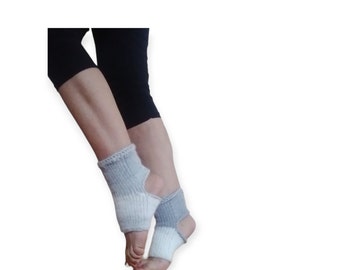 May include: A pair of grey and white knitted ankle warmers with a cut-out design on the back of the ankle.
