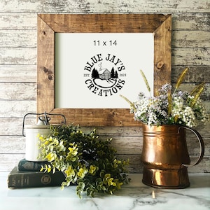 May include: A framed print with a black and white logo for Blue Jay's Creations. The logo features a cabin with smoke coming from the chimney, trees, and the text "Blue Jay's Creations Est. 2024". The frame is brown wood and the print is 11 x 14 inches.