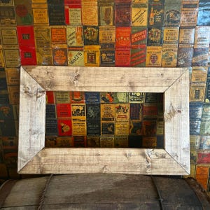 May include: A rustic wooden frame with a light brown finish. The frame is rectangular and has a slightly distressed look. The frame is empty and ready to be used to display a picture or other artwork.