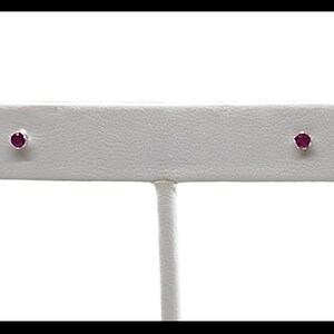 Peut inclure: Une paire de boucles d'oreilles en argent avec de petites pierres précieuses rondes roses.