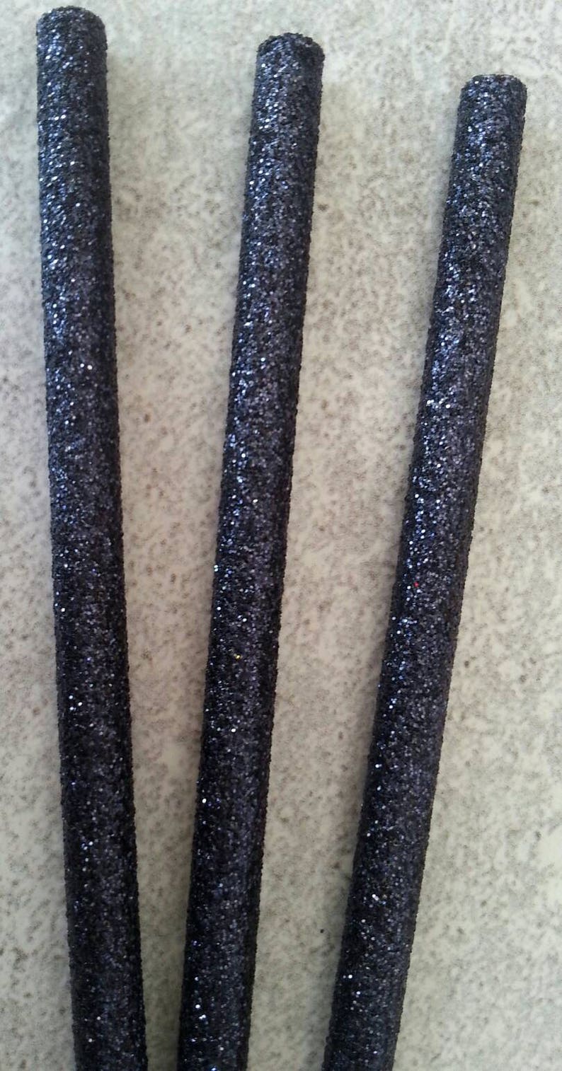 K&ouml;nnte beinhalten: Drei schwarze St&auml;be mit glitzernder Oberfl&auml;che. Die St&auml;be sind etwa 30 cm lang und vertikal angeordnet.