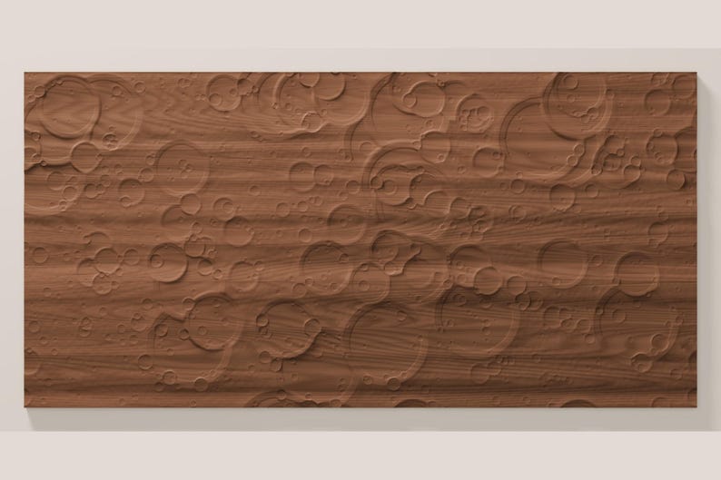 May include: A rectangular wooden panel featuring a carved surface texture that mimics the appearance of a cratered planetary landscape. The wood grain is visible throughout the brown surface, which is covered in various circular indentations.