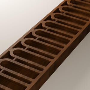 May include: A long, rectangular dark brown wooden block featuring a series of evenly spaced, arched cutouts along its length. The wood grain is visible on the surface, and the interior edges of the carved arch shapes are smooth and uniform.