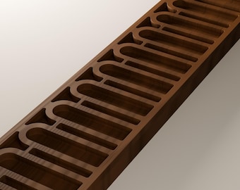 Puede incluir: Un bloque de madera largo y rectangular de color marrón oscuro que presenta una serie de recortes arqueados espaciados uniformemente a lo largo de su longitud. La veta de la madera es visible y los bordes internos son lisos.