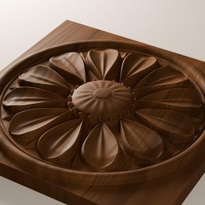 May include: A square wooden plaque featuring a circular medallion with a carved floral design. The center has a rounded, textured button shape surrounded by two layers of smooth, pointed petals, all set within a raised circular frame.