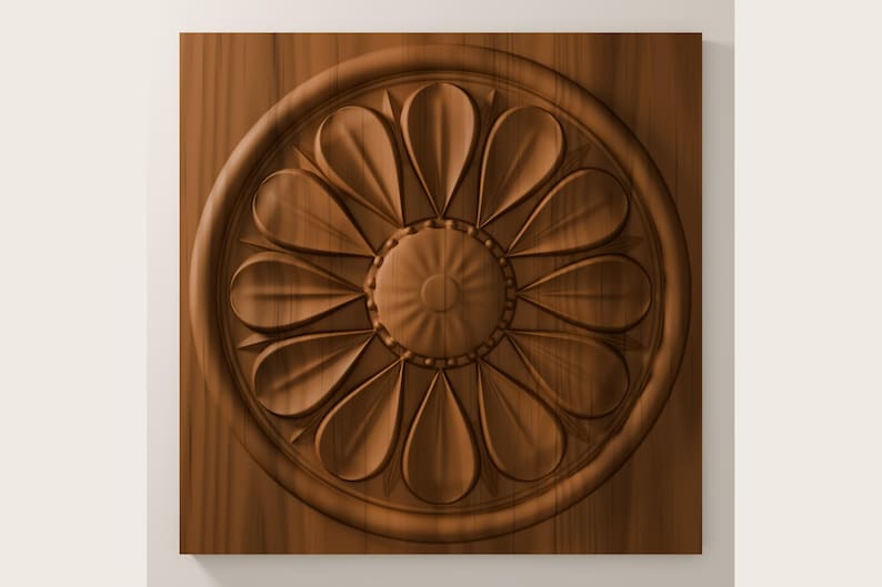 May include: A square wooden panel featuring a carved circular medallion in the center. The medallion displays a symmetrical floral pattern with twelve rounded petals radiating from a small, textured, circular hub, all in a warm brown tone.