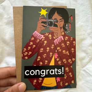 Félicitations ! Carte culturelle mignonne et audacieuse amusante - Design coloré vif, fille avec appareil photo, carte mate 4 x 6 avec enveloppe kraft, prend en charge les orphelins