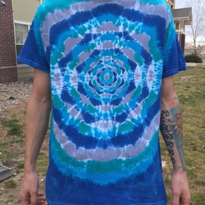 May include: A blue, green, and gray tie-dye t-shirt with a circular pattern.
