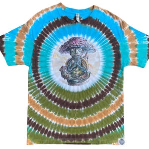 May include: A tie-dye t-shirt with a spiral pattern in shades of blue, brown, green, and tan. The shirt features a central graphic of a mushroom-headed figure in a meditative pose. The design is detailed and colorful, with a psychedelic aesthetic.
