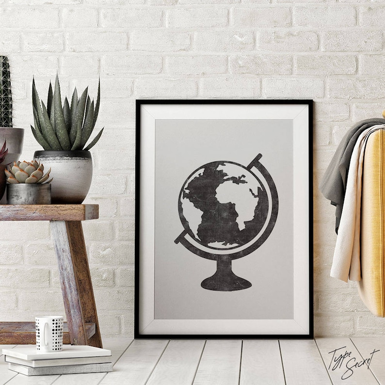May include: Black and white print of a globe on a stand in a black frame. The globe is a stylized illustration of the Earth with continents and oceans.