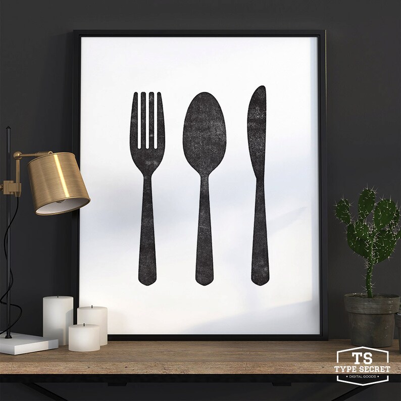 May include: Black and white print of a fork, spoon, and knife on a white background. The print is framed in a black frame.