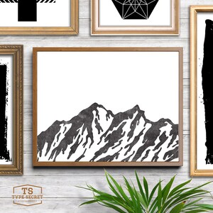 May include: Black and white illustration of a mountain range with a textured look. The image is framed in a brown wood frame.
