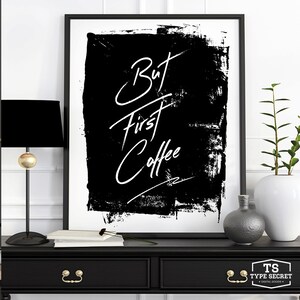 May include: Black and white art print with the text "But first coffee" in a white handwritten font on a black background with a white border.