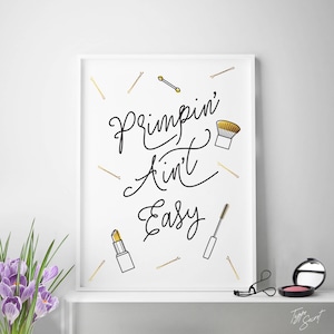 May include: A white framed print with black text that reads "Primpin' Ain't Easy" with gold hair clips and makeup illustrations.