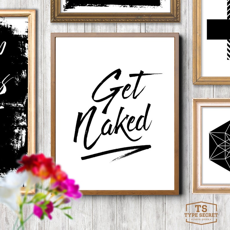 Peut inclure: Une impression d'art mural imprimable en noir et blanc avec le texte "Get Naked" dans une police d'&eacute;criture manuscrite audacieuse. L'impression est encadr&eacute;e dans un cadre en bois brun clair.