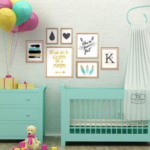 K&ouml;nnte beinhalten: Ein hellblaues Babybett mit einem wei&szlig;en Baldachin, eine hellblaue Kommode mit drei Schubladen und ein gelber, rosa und blauer Ballonstrau&szlig;. Die Wand ist mit gerahmten Drucken dekoriert, die ein schwarzes Herz, eine schwarze Tr&auml;ne, ein schwarz-wei&szlig;es abstraktes Design, einen goldenen Pfeil mit dem Text "Though she be but little she is fierce", ein schwarz-wei&szlig;es Katzen Gesicht mit dem Text "You're pawfect" und einen goldenen Buchstaben K zeigen.